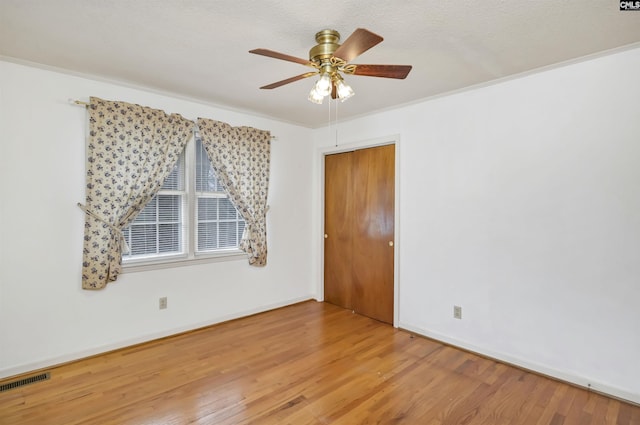 unfurnished room with crown molding, ceiling fan, a textured ceiling, and hardwood / wood-style flooring