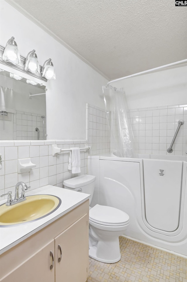 full bathroom featuring vanity, tile patterned flooring, toilet, a textured ceiling, and tile walls