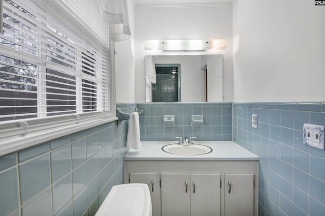 bathroom with crown molding, vanity, and tile walls