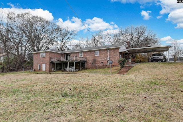 rear view of property featuring a carport, a deck, and a yard