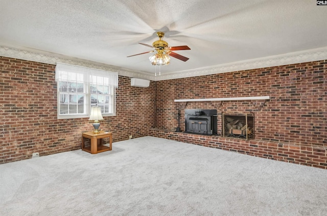 unfurnished living room featuring carpet, a wood stove, an AC wall unit, and brick wall