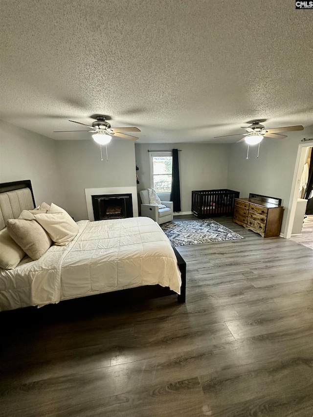 bedroom featuring ceiling fan, hardwood / wood-style floors, and a textured ceiling