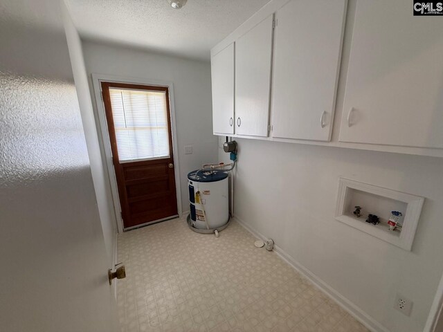 clothes washing area featuring cabinet space, hookup for a washing machine, baseboards, light floors, and electric water heater