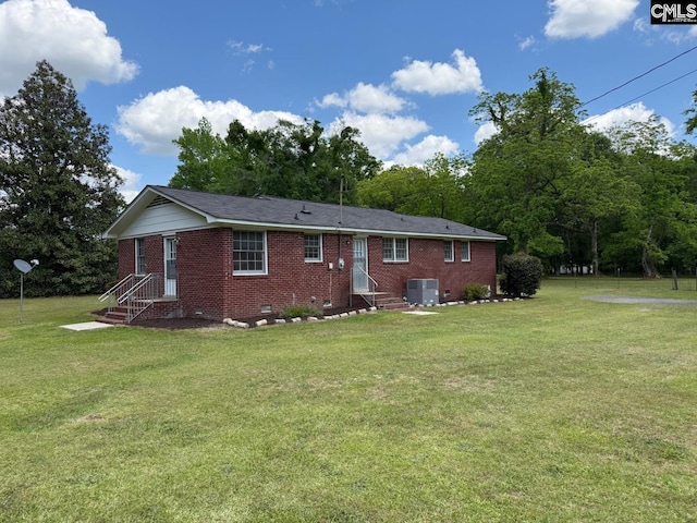 back of house featuring brick siding, crawl space, a yard, and entry steps