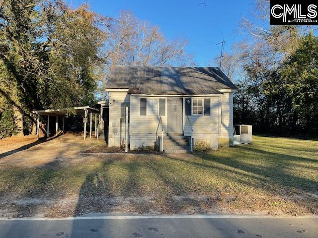 bungalow-style home with a front yard and a carport