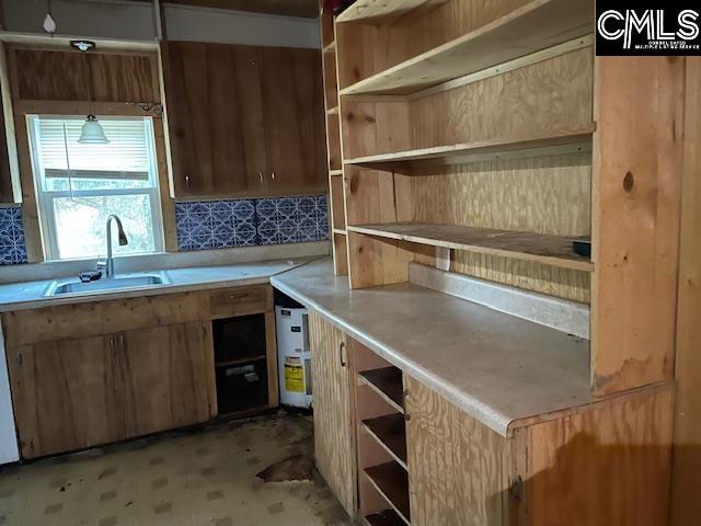 kitchen with backsplash, dishwashing machine, sink, and decorative light fixtures