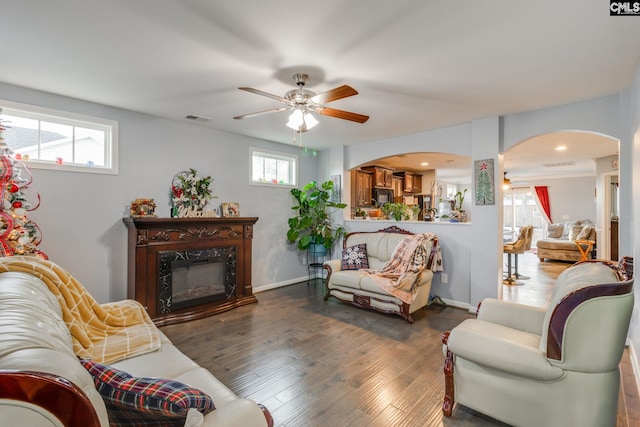 living room with a fireplace, dark hardwood / wood-style floors, and ceiling fan