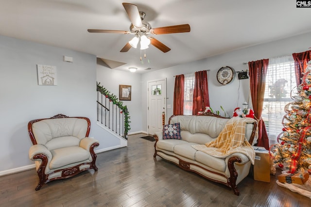 living room featuring ceiling fan and dark wood-type flooring