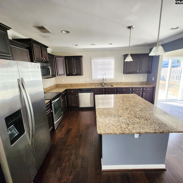 kitchen featuring crown molding, sink, hanging light fixtures, a kitchen island, and stainless steel appliances