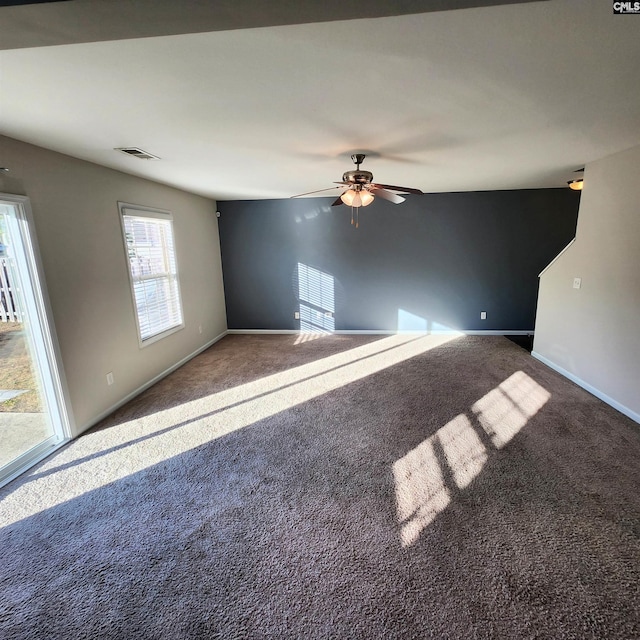 empty room with carpet, ceiling fan, and a healthy amount of sunlight