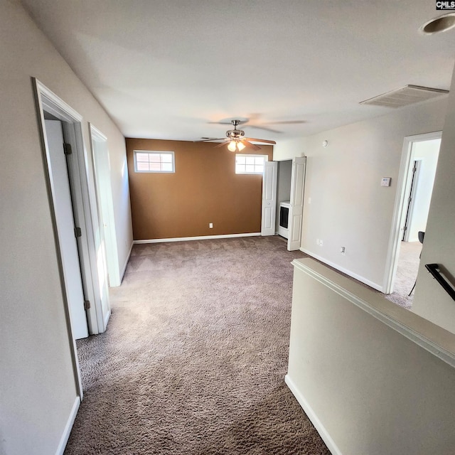 carpeted spare room featuring ceiling fan