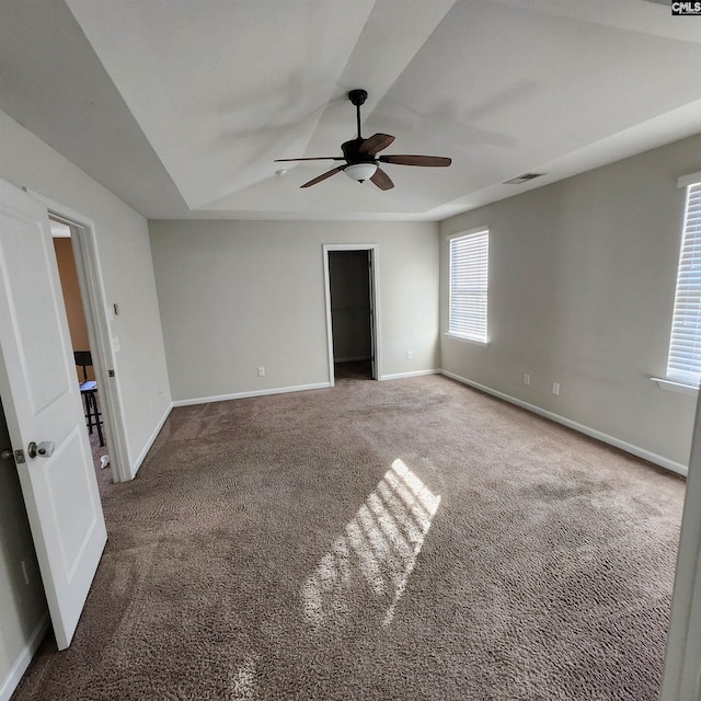 unfurnished room with carpet, ceiling fan, and a tray ceiling