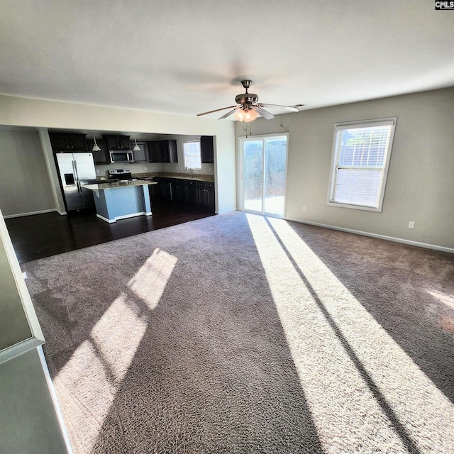 kitchen with ceiling fan, sink, stainless steel appliances, and dark carpet