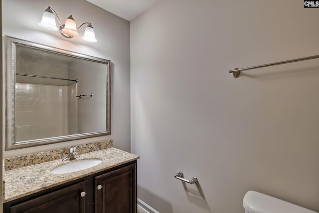 bathroom featuring vanity, toilet, and walk in shower