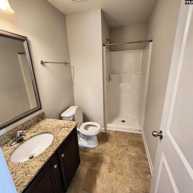 bathroom with toilet, vanity, and walk in shower