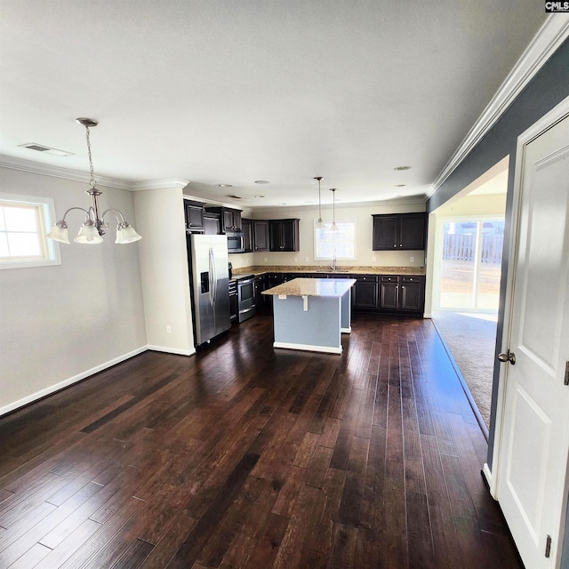 kitchen with pendant lighting, an inviting chandelier, sink, a kitchen island, and stainless steel appliances