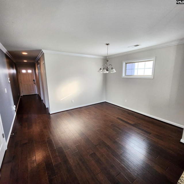 spare room featuring a notable chandelier, dark hardwood / wood-style floors, and crown molding