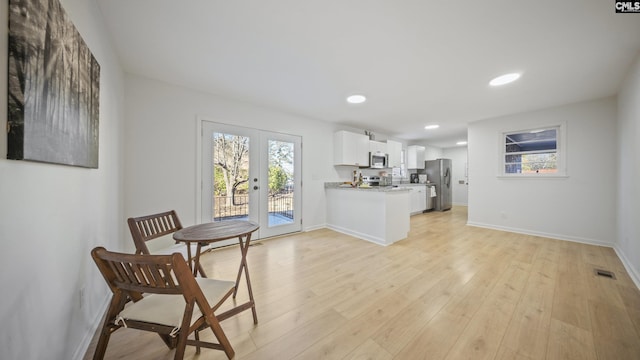 kitchen featuring white cabinetry, french doors, light hardwood / wood-style floors, and appliances with stainless steel finishes