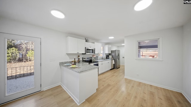 kitchen featuring white cabinets, sink, light hardwood / wood-style floors, light stone counters, and stainless steel appliances