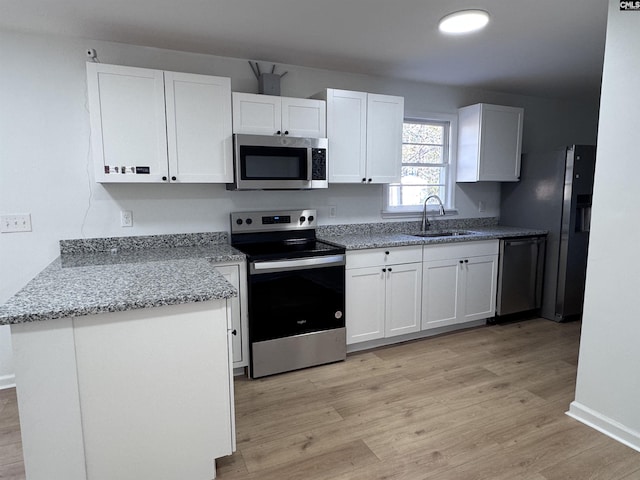 kitchen featuring sink, white cabinets, light hardwood / wood-style floors, and appliances with stainless steel finishes