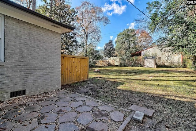 view of yard featuring a storage unit and a patio