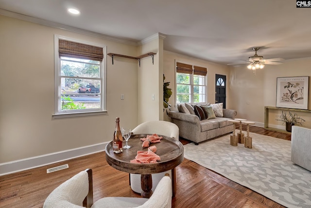 living room featuring ceiling fan, wood-type flooring, and ornamental molding