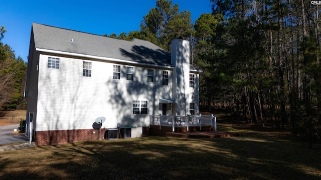 rear view of property with a wooden deck, a yard, and central AC unit