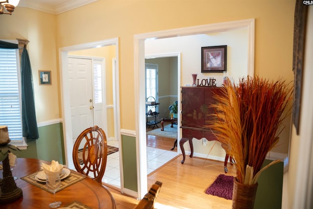 dining area featuring light wood-type flooring and ornamental molding