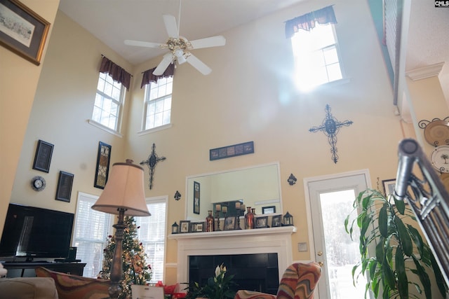 living room with ceiling fan and a towering ceiling