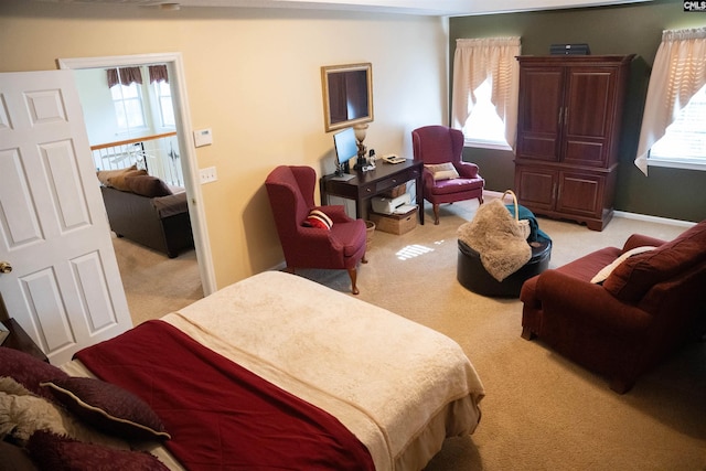 bedroom featuring light carpet and multiple windows