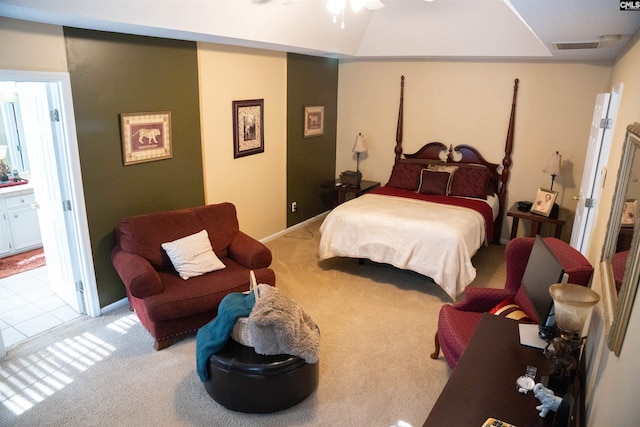 carpeted bedroom with ensuite bathroom and ceiling fan