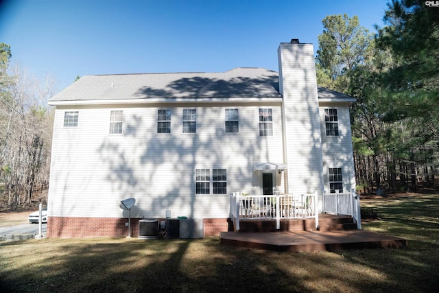 back of property featuring a yard, central AC unit, and a deck