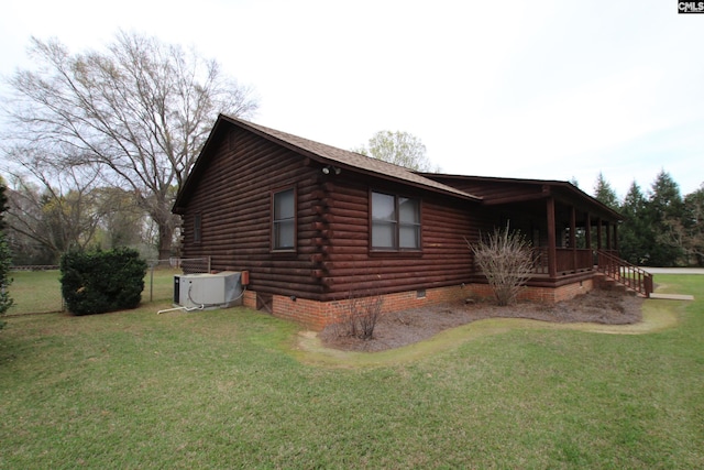 view of side of home with central AC unit and a yard