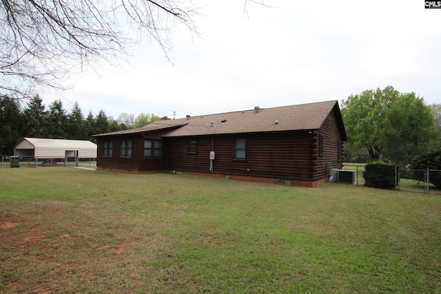 rear view of house with a yard and central air condition unit