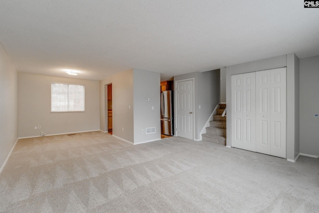 interior space with light carpet and a textured ceiling