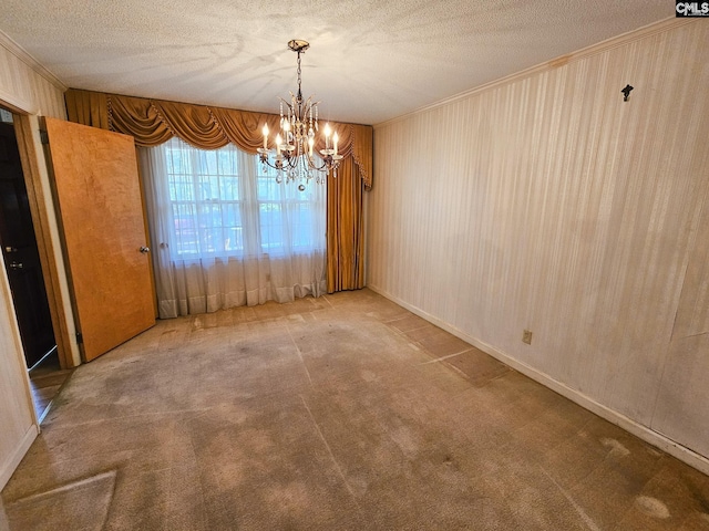 unfurnished dining area featuring carpet floors, ornamental molding, a textured ceiling, and an inviting chandelier