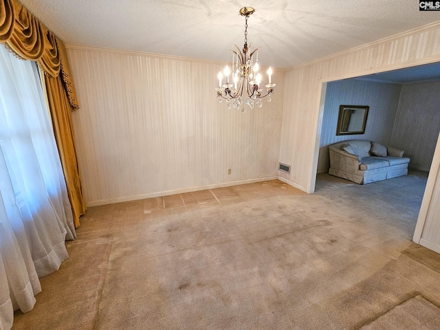 unfurnished dining area with wooden walls, a textured ceiling, light colored carpet, and a notable chandelier