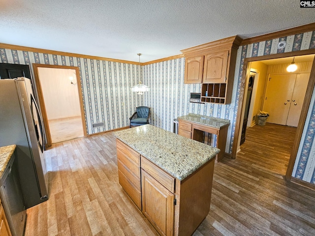 kitchen featuring stainless steel fridge, a textured ceiling, pendant lighting, hardwood / wood-style floors, and a kitchen island