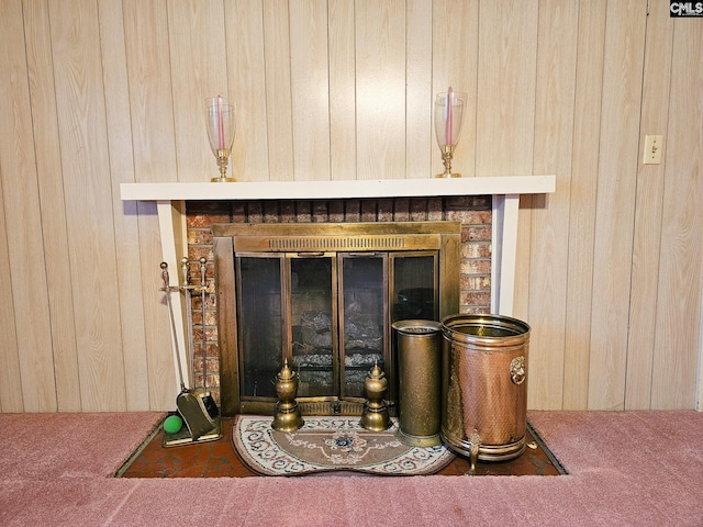 room details with wood walls, a fireplace, and carpet floors