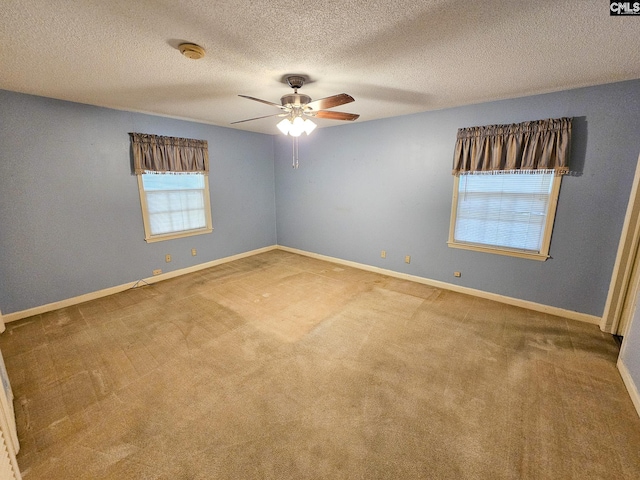 spare room featuring carpet, a textured ceiling, and ceiling fan