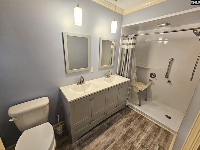 bathroom featuring walk in shower, hardwood / wood-style floors, toilet, vanity, and ornamental molding