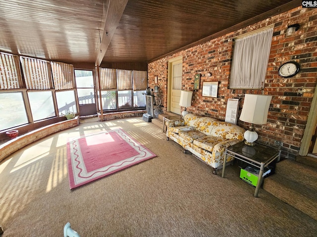 unfurnished living room featuring beam ceiling, carpet floors, wood ceiling, and brick wall