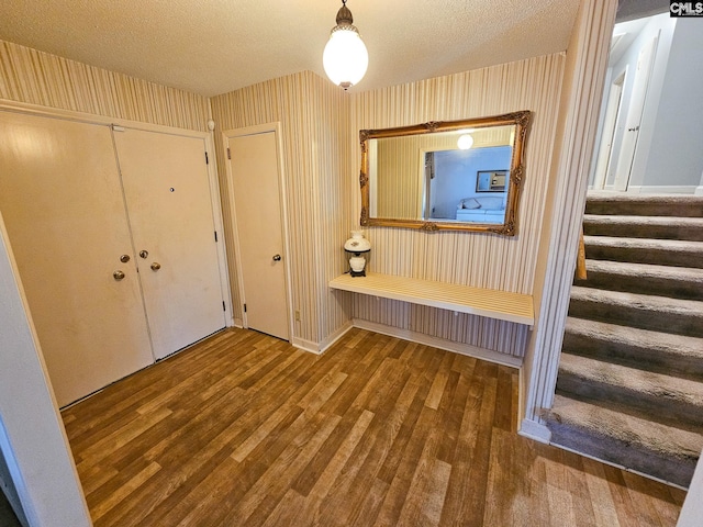 entryway with wood-type flooring and a textured ceiling