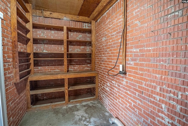 interior space with concrete floors and brick wall