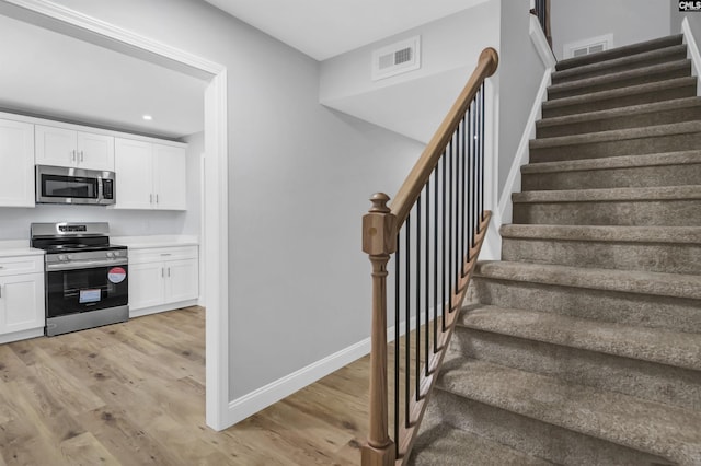 stairs featuring hardwood / wood-style floors