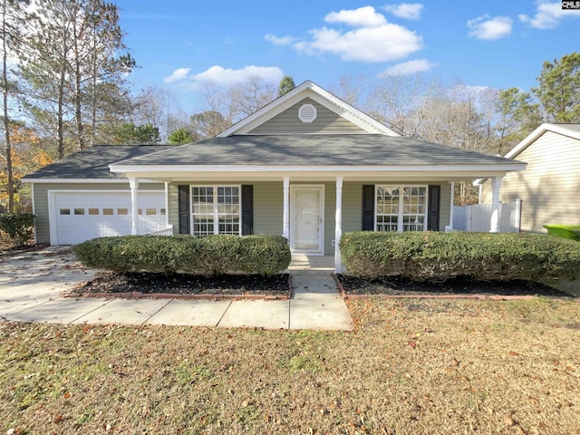 view of front of home featuring a porch, a front yard, and a garage