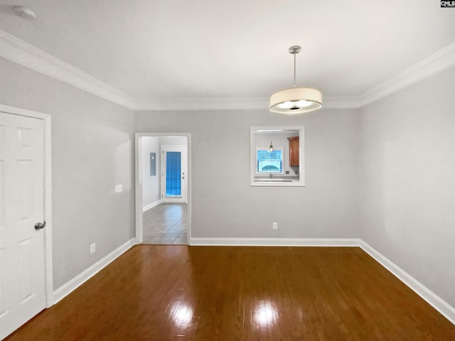 empty room featuring dark hardwood / wood-style flooring and ornamental molding