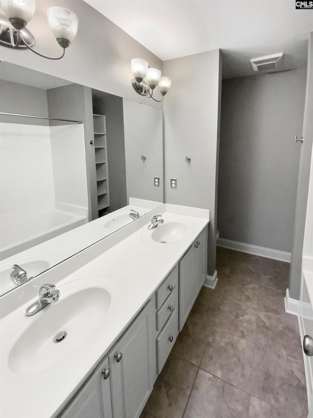 bathroom featuring tile patterned flooring, a bath, vanity, and a notable chandelier