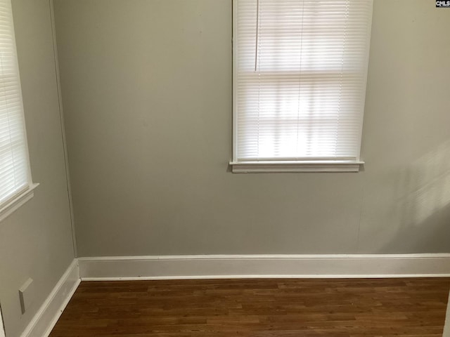 unfurnished room featuring plenty of natural light and dark wood-type flooring