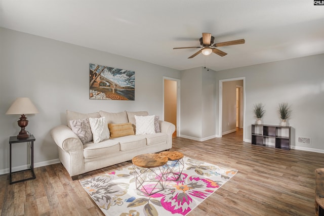 living room featuring wood-type flooring and ceiling fan